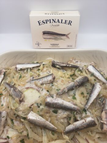 Image of Espinaler premium line sardinas 20/25 in a cassarole dish in potato gratin