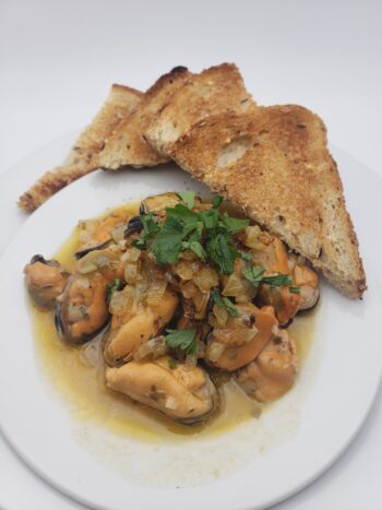 Image of Patagonia lemon herb mussels plated with toast