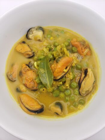 Image of Patagonia smoked mussels plated with curry and peas