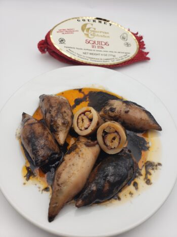 Image of conservas de cambados squid in ink on plate with bisections