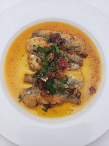 Image of La Brujula fried sardines in sauce #35 plated with parsley