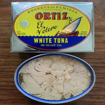 Image of the outer package and an open tin of Ortiz Family Reserve Bonito del Norte in Extra Virgin Olive Oil