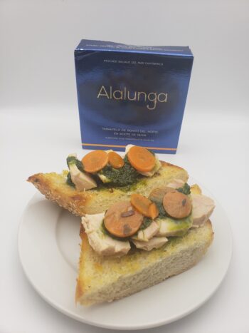 Image of Alalunga Bonito del Norte plated on toasted baguette with herb pesto and escabeche carrots