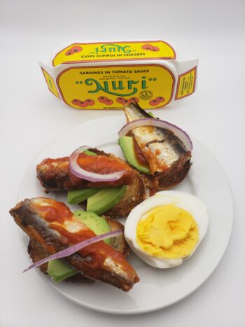 IMage of Nuri sardines in tomato sauce on crostini with avocado and red onion