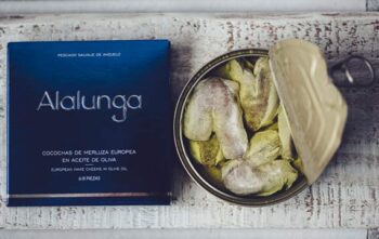 Image of the front of a package and an open tin of Artesanos Alalunga Cocochas de Merluza Europea (European Hake Cheeks) in Olive Oil 6/8