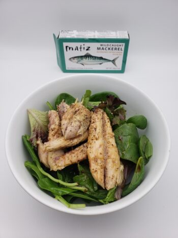 Image of Matiz wild mackerel on a bed of greens with cracked pepper and lemon