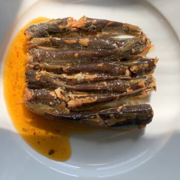 Image of the contents of an inverted tin of Les Mouettes d'Arvor Sardinettes in Olive Oil with Piment d'Espelette 8/10