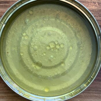 Image of the tinning liquid from a tin of Artesanos Alalunga Cocochas de Merluza Europea (European Hake Cheeks) in Olive Oil 6/8