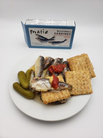 Image of Matiz sardines with sweet piquillo peppers plated with crackers and cornichons