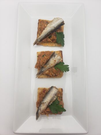 Image of King Oscar cross packed sardines on crackers with tapenade