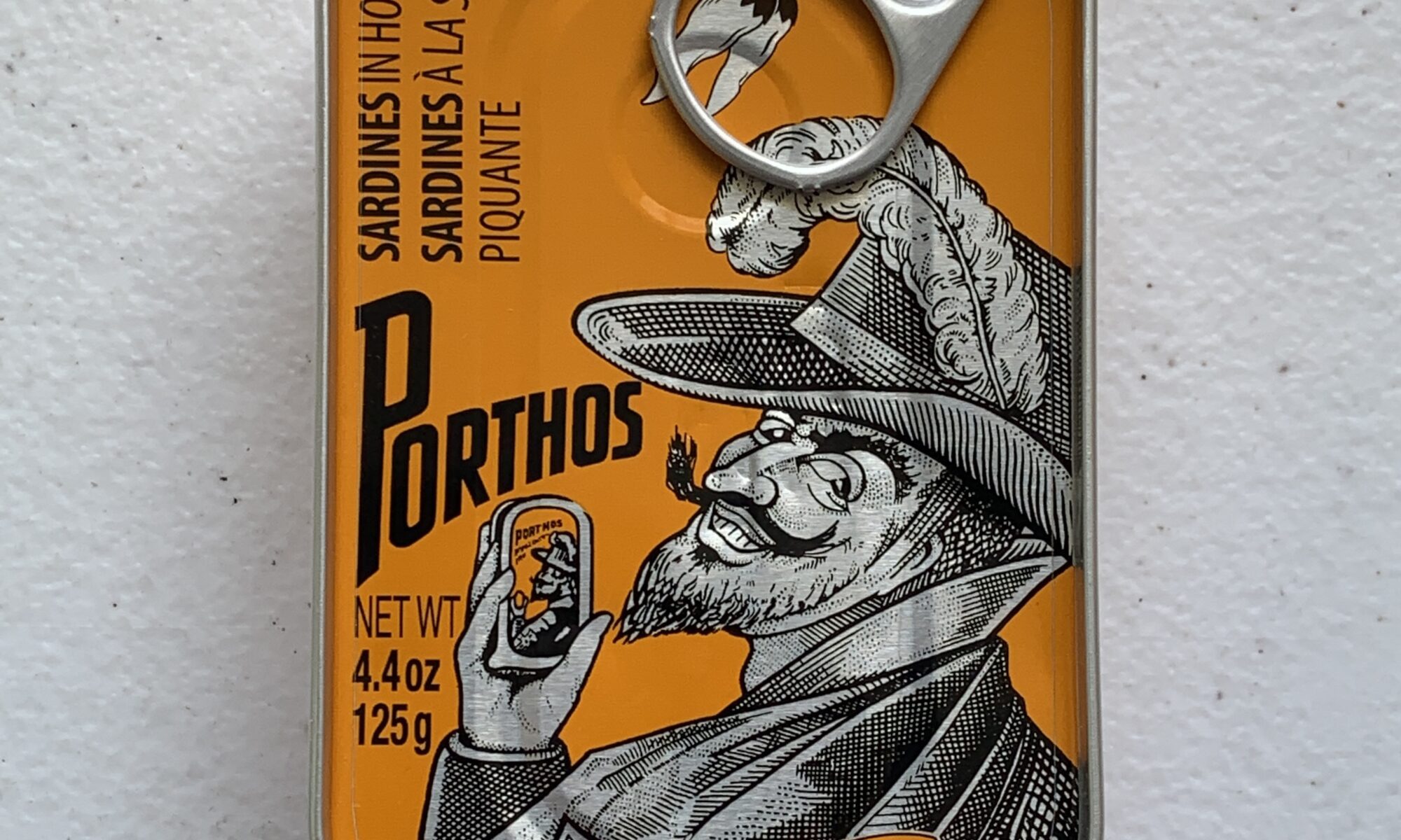 Image of the front of a tin of Porthos Sardines in Hot Tomato Sauce