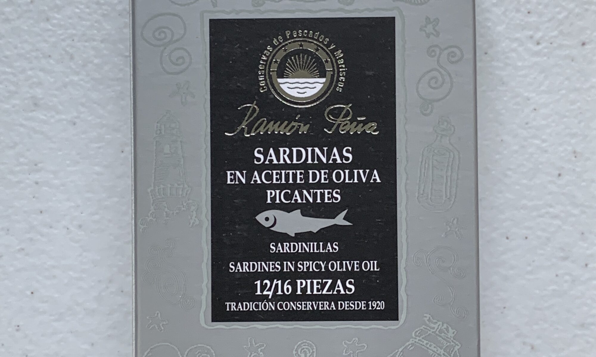 Image of the front of a package of Ramón Peña Small Sardines in Spicy Olive Oil 12/16