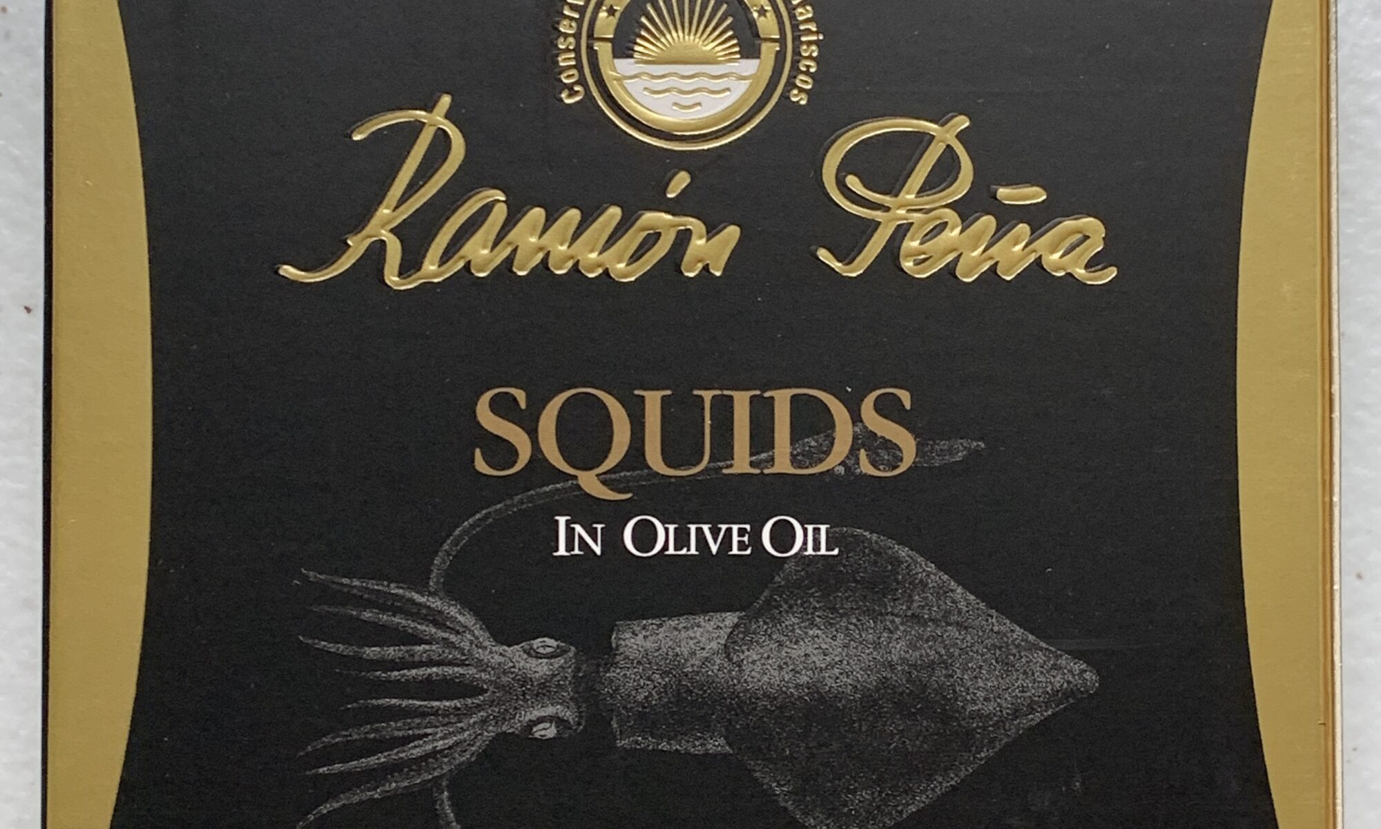 Image of the front of a package of Ramón Peña Squids in Olive Oil