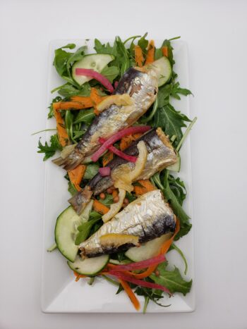 Image of Jacques Gonidec sardines with lemon on arugula, cucumbers, carrots, and dill