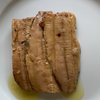 Image of the contents of a tin of Les Mouettes d’Arvor Sardine Fillets in Extra Virgin Olive Oil inverted onto a plate.