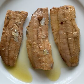 Image of the contents of a tin of Les Mouettes d’Arvor Sardine Fillets in Extra Virgin Olive Oil inverted onto a plate and separated .