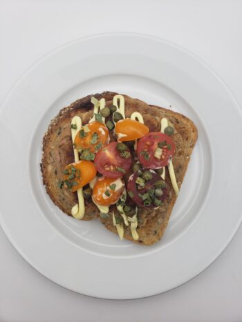 Image of Coles Tuna in Olive oil as a patty on toast with tomatoes and chives