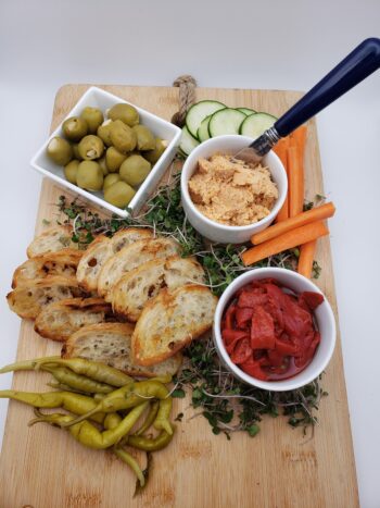 Image of Groix & Nature salmon rillettes on a board with crostini, pickled vegetables, and olives