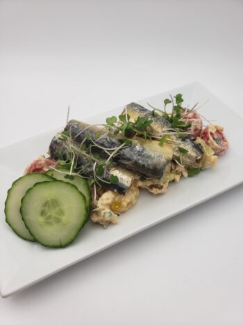 Image of Minerva sardines with piri piri and olive oil plated on chickpea salad
