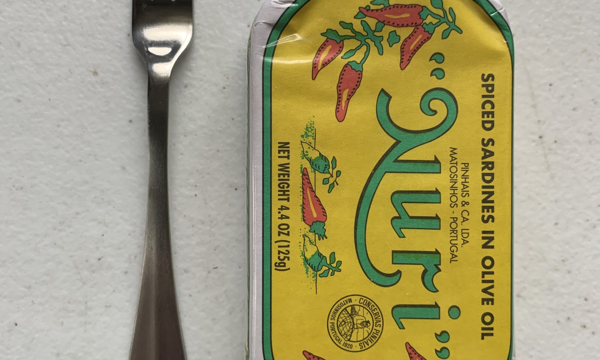 Image of a Cocktail Fork, Choice Midland, Stainless Steel, Medium Weight next to a tin of sardines for scale