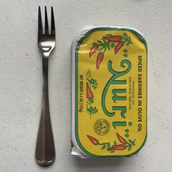 Image of a Cocktail Fork, Choice Midland, Stainless Steel, Medium Weight next to a tin of sardines for scale