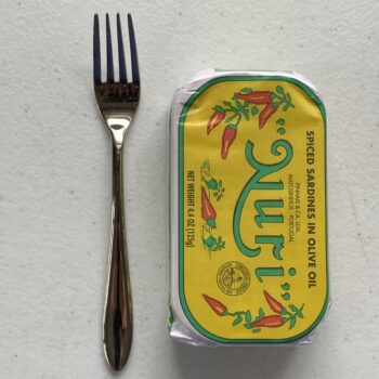 Image of a Cocktail Fork, Acopa Remy, Stainless Steel, Extra Heavy Weight next to a tin of sardines for scale.