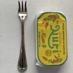 Image of a Cocktail Fork, Reed & Barton Chestnut Hill, Stainless Steel, Extra Heavy Weight next to a tin of sardines for scale.