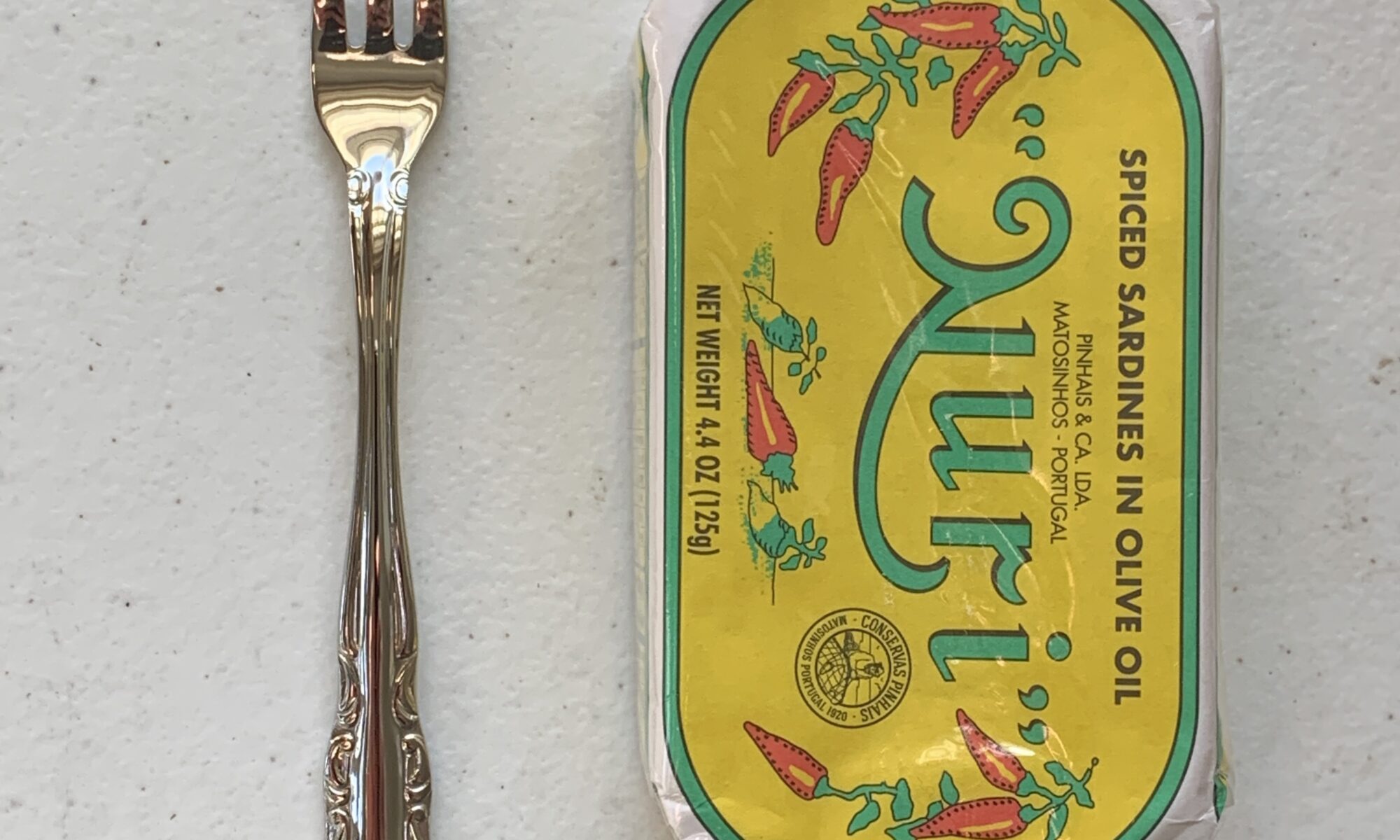Image of a Cocktail Fork, Walco Discretion, Stainless Steel, Heavy Weight next to a tin of sardines for scale