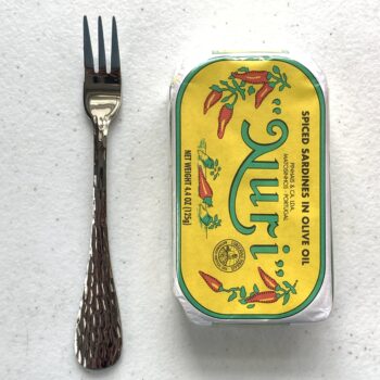 Image of a Cocktail Fork, Acopa Industry, Stainless Steel, Heavy Weight next to a tin of fish for scale