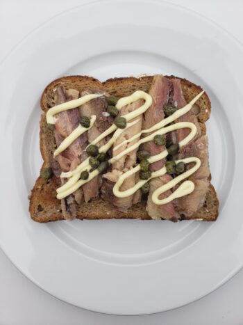 Image of bon appetit skinless boneless sardines on wheat toast with mayo and capers