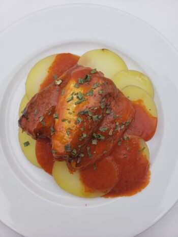 Image of bon appetit sardines with hot tomato sauce plated on potatoes with chives