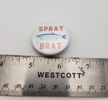 Image of sprat brat pinback button with ruler for scale