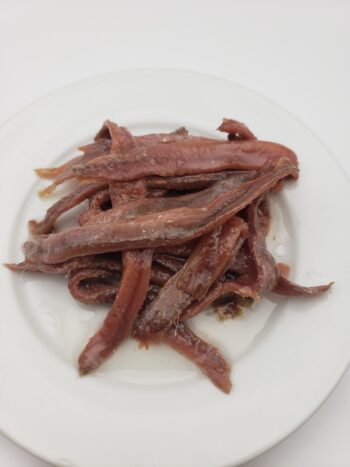 IMage of ortiz anchovies in oil jar on plate