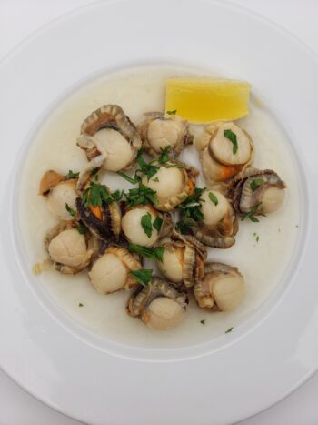 Image of Real Conservas variegated scallops plated with lemon and parsley