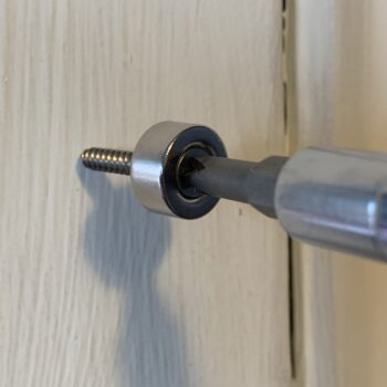 Image of screwing the magnet to the wall.