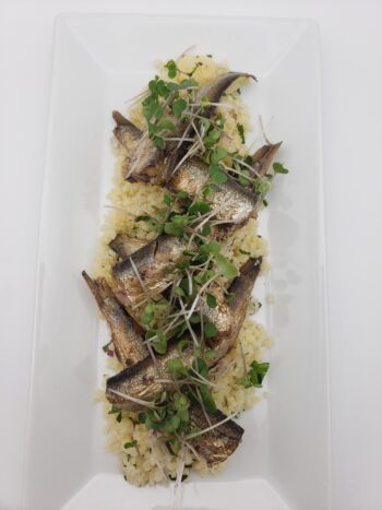 Image of Belveder smoked sprats 160g plated on cous cous tabbouleh