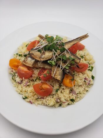 Image of Belveder smoked sprats 240g on cous cous tabbouleh with tomatoes and kale microgreens