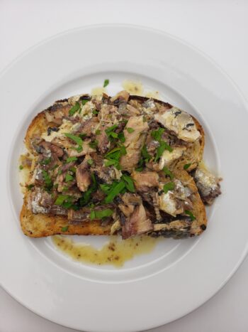 Image of Ferrigno sardines a la beurre on toast with parsely