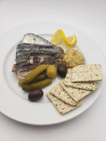 Image of Yurrita sardines plated with mustard, pickles, and crackers