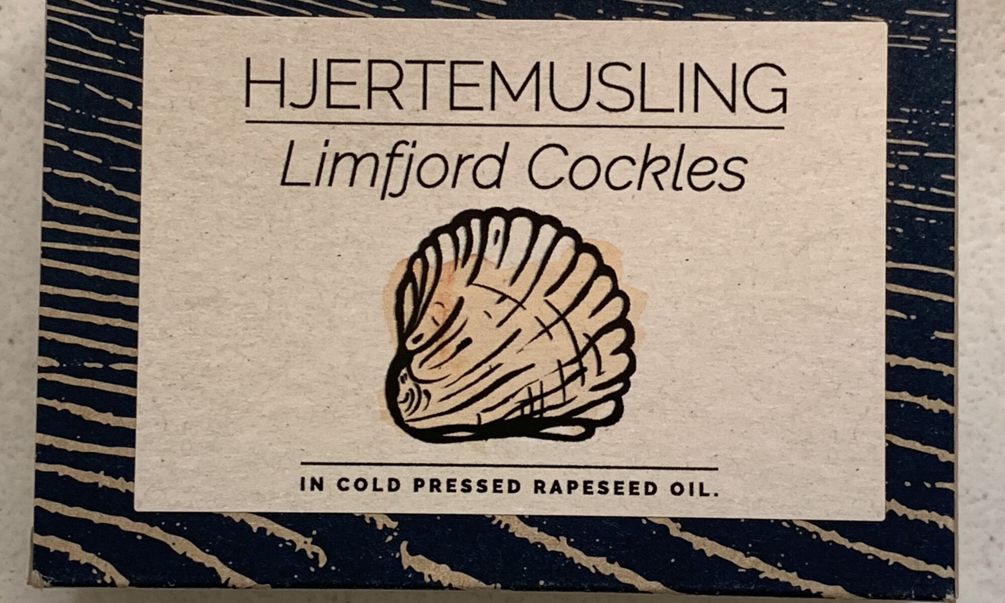 Image of the front of a package of Fangst Limfjord Hjertemusling (Cockles) in Cold Pressed Rapeseed (Canola) Oil
